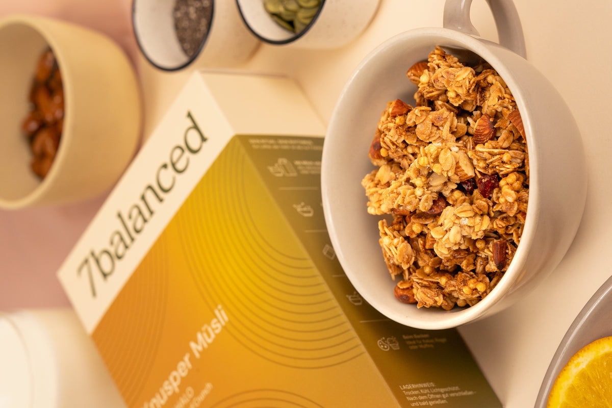 Scoop of crunchy Honey Halo granola beside yellow bag packaging