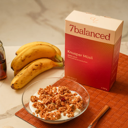 Berry granola box with granola in a glass bowl and sliced bananas